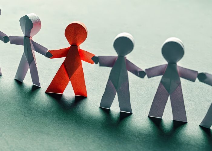 Colorful paper cutout figures holding hands, symbolizing unity, diversity, equality, on blue background, representing community support, collaboration, inclusivity, teamwork, multicultural society Diverse paper people chain on blue surface, inclusion, unity, teamwork. symbolize equal rights, community support, harmonious multicultural society. Concept solidarity, partnership, togetherness